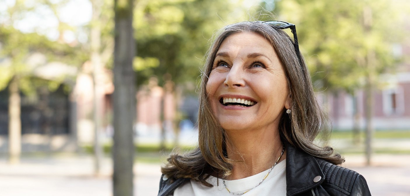 Portrait of smiling, mature woman standing outdoors