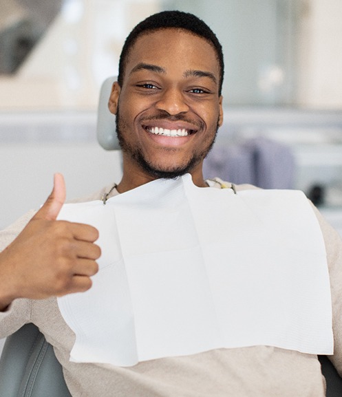 Happy dental patient making thumbs-up gesture