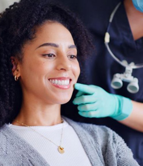 Dental patient looking at her smile in mirror