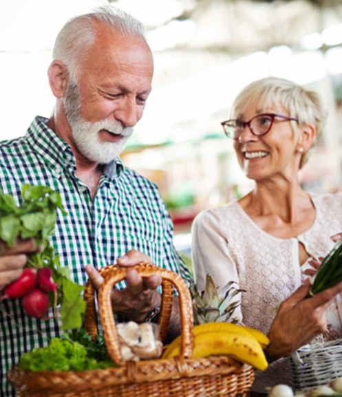 Older man and woman at farmer’s market shopping 