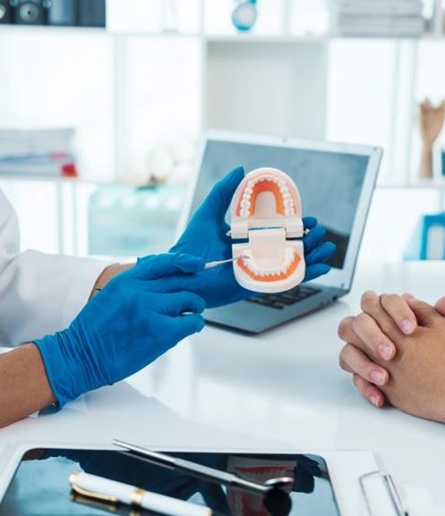 Dentist and patient sitting at desk during consultation