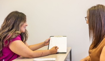Dental team member filling out paperwork on a clipboard
