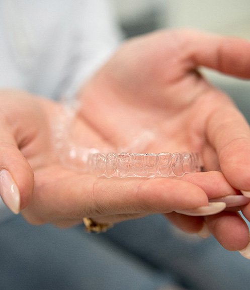 Closeup of patient holding clear aligner