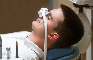 Patient relaxing while breathing in nitrous oxide in treatment chair