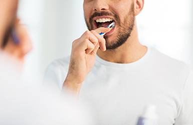 Nose-to-chest view of man brushing teeth